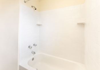 Bathroom with white tiles and a white bathtub